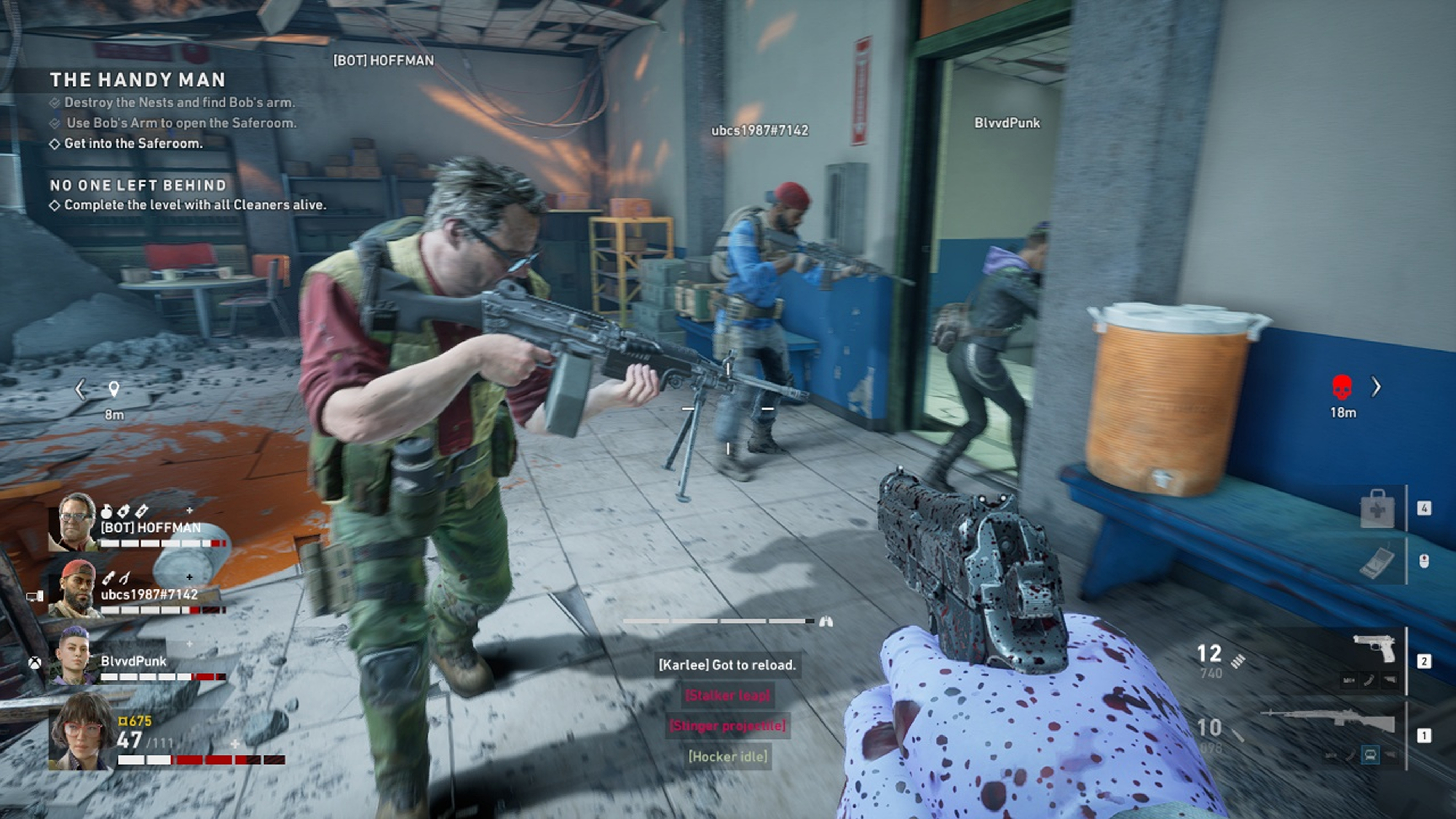 Another screenshot, this time showing a multiplayer session. The player is aiming at one of their colleagues. The player can see two other colleagues going inside a room. The area looks like the indoor area of a building. The walls are white with blue stripes in the bottom part. There are many game HUD elements on screen, showing the current health of all players and the weapons equipped by the player, a rifle and a handgun. Some objectives are displayed on the top left of the screen..